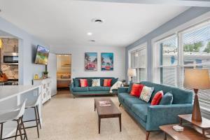 a living room with two blue couches and a kitchen at Heated Pool by the Sea Mini Golf Dogs OK in Saint Augustine