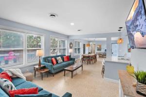 a living room with blue couches and a kitchen at Heated Pool by the Sea Mini Golf Dogs OK in Saint Augustine