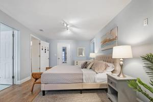 a white bedroom with a bed and a lamp at Heated Pool by the Sea Mini Golf Dogs OK in Saint Augustine +56 photos
