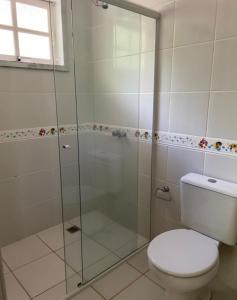 W łazience znajduje się toaleta i przeszklony prysznic. w obiekcie casa de campo em chacará w mieście Kurytyba