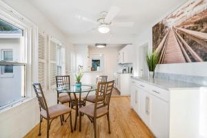 a dining room with a table and chairs and a kitchen at Beach Cottage! 100 Steps to the Sand, Pets OK, Private Deck! in Saint Augustine