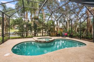 a swimming pool in a glass house with a swimming poolvisor at Pool + Hot Tub, Dock, Fishing, Near Beach! in St. Augustine
