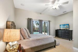 a bedroom with a bed and a ceiling fan at Pool + Hot Tub, Dock, Fishing, Near Beach! in St. Augustine