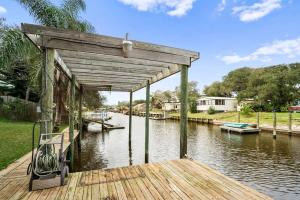 a wooden dock with a covering over a body of water at Pool + Hot Tub, Dock, Fishing, Near Beach! in St. Augustine