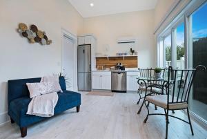 ein Wohnzimmer mit einem blauen Sofa und einem Tisch in der Unterkunft Mod Studio - 100 Steps to the Beach, Pets OK, Private Deck! in St. Augustine
