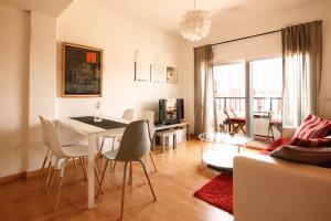 a living room with a table and chairs and a living room at LUMINOSO. COMODO. ACOGEDOR. WIFI. Junto a AVE in Valencia
