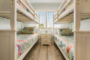 2 Etagenbetten in einem Zimmer mit Fenster in der Unterkunft Spectacular Oceanfront! Blissful Balconies + BBQ in St. Augustine