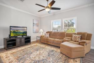 a living room with a couch and a flat screen tv at Canal Front Home! Walk to Beach, Porch, Fishing in St. Augustine