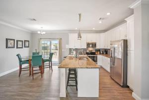 a kitchen with white cabinets and a table and chairs at Canal Front Home! Walk to Beach, Porch, Fishing in St. Augustine