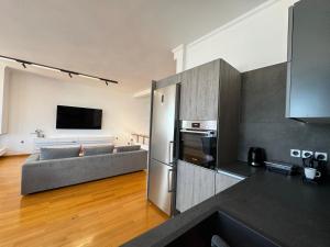 a kitchen and living room with a couch and a television at S&F Luxury Apartment in Nafplio