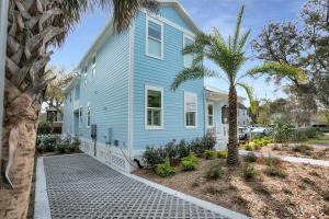 a blue house with a palm tree in front of it at Blue House, Prime Location, Family Amenities, BBQ! in Saint Augustine