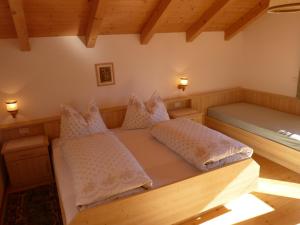 two beds in a room with wooden ceilings at Oberpapping in San Candido