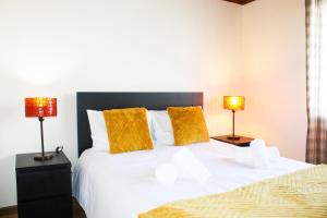 a bedroom with a large white bed with two lamps at Vieira Rooms Natural Pools in Ponta Delgada