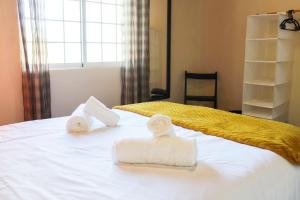 Un dormitorio con una cama con toallas. en Vieira Rooms Natural Pools, en Ponta Delgada
