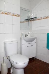 Un baño blanco con inodoro y lavabo. en Vieira Rooms Natural Pools, en Ponta Delgada