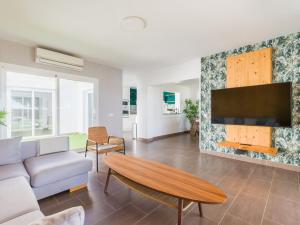a living room with a couch and a tv at Pasito Blanco Villas in Pasito Blanco