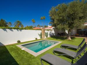 a backyard with a swimming pool and two lawn chairs at Pasito Blanco Villas in Pasito Blanco