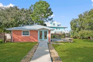 una pequeña casa con una naranja y blanco en Coral Cottage, Stylish Studio Suite on Canal, Walkable to Beach, Private Parking, en St. Augustine