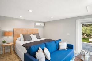 1 dormitorio con 1 cama y 1 sofá azul en Coral Cottage, Stylish Studio Suite on Canal, Walkable to Beach, Private Parking, en St. Augustine