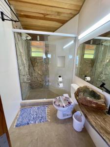 a bathroom with a shower and a toilet at Mirante do Pirata Suítes Bed and Breakfast in Ubatuba