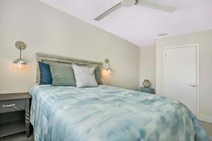 a bedroom with a large bed with a ceiling fan at Ocean Views Retreat! Renovated Apt with Beach Bikes! in Saint Augustine