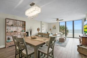 Un comedor y una sala de estar con mesa y sillas. en Upscale Oceanfront Condo with Panoramic Views and Pool, en St. Augustine