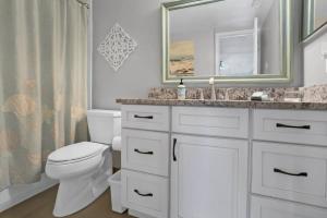 Un baño con inodoro, lavabo y espejo. en Upscale Oceanfront Condo with Panoramic Views and Pool, en St. Augustine 25 fotos más