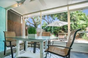 a table with chairs and an umbrella on a patio at Sapphire Skies! Sweet Beach Condo Steps from the Sand and Surf in St. Augustine