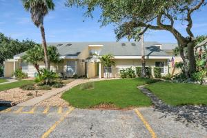 a house with palm trees and a driveway at Sapphire Skies! Sweet Beach Condo Steps from the Sand and Surf in Saint Augustine
