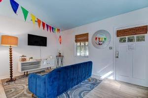 a living room with a blue couch and a tv at Uptown Treasure with Spa Dogs Ok Dreamy Patio in Saint Augustine