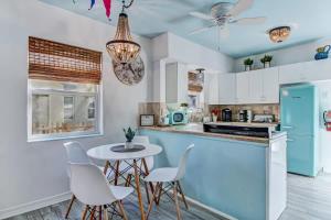 a kitchen with a blue refrigerator and white cabinets at Uptown Treasure with Spa Dogs Ok Dreamy Patio in St. Augustine