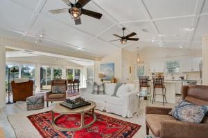 a living room with a white couch and a table at Charming Fishing Cabin Has It All, Full Dock and Summer Kitchen, Access to SUPs, Bikes, Beach Gear in Palm Coast