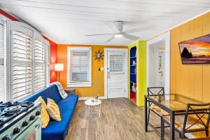 a living room with a blue couch and a stove at Marvelous Mermaid Bungalow, Dog-Friendly Downstairs Apt in Prime Vilano Beach in Saint Augustine