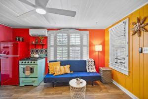 ein Wohnzimmer mit einem blauen Sofa und einem Herd in der Unterkunft Marvelous Mermaid Bungalow, Dog-Friendly Downstairs Apt in Prime Vilano Beach in St. Augustine
