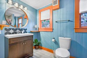 a blue bathroom with a toilet and a mirror at Marvelous Mermaid Bungalow, Dog-Friendly Downstairs Apt in Prime Vilano Beach in Saint Augustine +30 photos