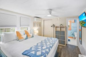 1 Schlafzimmer mit einem großen Bett und einem Badezimmer in der Unterkunft Marvelous Mermaid Bungalow, Dog-Friendly Downstairs Apt in Prime Vilano Beach in St. Augustine