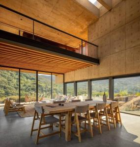 Un comedor con una gran mesa y sillas de madera. en Casa Zilin - Cuatro Cuatros, en Valle de Guadalupe