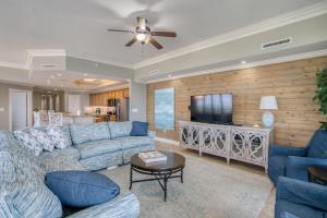 a living room with a couch and a flat screen tv at Phoenix West II 1901 Wrap-Around Balcony in Orange Beach