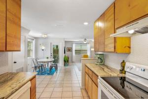 a kitchen with wooden cabinets and a table in it at The Atomic Burst 50s Mid Century Apt in the Heart of St Aug Beach Steps to Sand Bites and Drinks in Saint Augustine