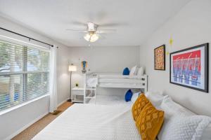 a white bedroom with a bed and a window at The Atomic Burst 50s Mid Century Apt in the Heart of St Aug Beach Steps to Sand Bites and Drinks in Saint Augustine