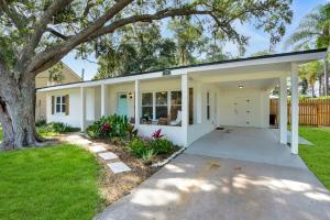 una casa blanca con un árbol en el patio en Rave Reviews for Waterway Views Spa Comfy Beds Bring Your Boat, en St. Augustine