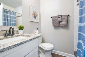 Un baño blanco con lavabo e inodoro. en Rave Reviews for Waterway Views Spa Comfy Beds Bring Your Boat, en St. Augustine