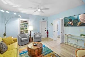 a living room with a yellow couch and a tv at Garden Views in Lincolnville Walk DT Dogs OK in St. Augustine