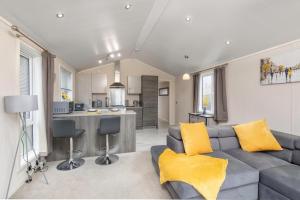 een woonkamer met een bank en een keuken bij Family Luxury York Cabin Retreat with hot tub in York