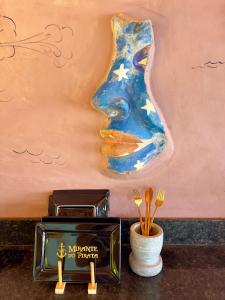 una pintura de una mujer con un tenedor en un jarrón en Mirante do Pirata Suítes Bed and Breakfast en Ubatuba