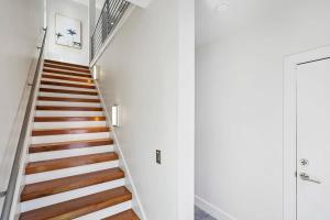 a staircase in a house with white walls and wooden floors at Ocean Views Sunrises and Sunsets Sparkling Pool and Spa Steps to Sand in Saint Augustine +110 photos