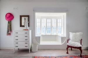 Habitación blanca con vestidor y ventana en Kalimera Beach House, en Mossel Bay 122 fotos más