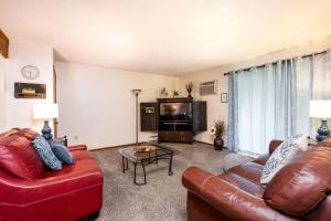 uma sala de estar com um sofá de couro e uma televisão em Family-friendly cottages by Lake Bella Vista em Rockford