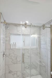 La salle de bains est pourvue d'une douche avec une porte en verre. dans l'établissement The Lincolnville Loft Sunny Patio with BBQ, à Saint Augustine