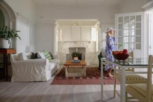 a woman standing in a living room with a fireplace at Kalimera Beach House in Mossel Bay